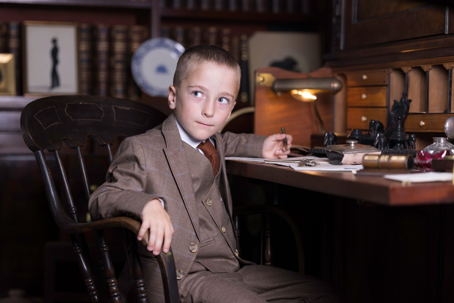Little boy busy writing in his study